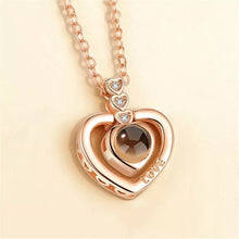 Load image into Gallery viewer, Beautiful stainless steel chain with cubic zirconia setting heart pendant that projects &quot;I love you&quot; in 100 languages visible up close or projected out above with flash light.   One of a kind gift for that special someone this Valentines, Anniversary or just because you want to say I you love in 100 different ways.  Chain 41 cm.  Pendant 1.7 cm.  Please follow care instructions to maintain your pieces quality and integrity. #ShopEmmaSofia
